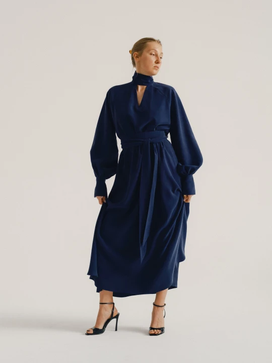 Modelka w eleganckiej granatowej sukience maxi uszytej z miękkiej wiskozy.